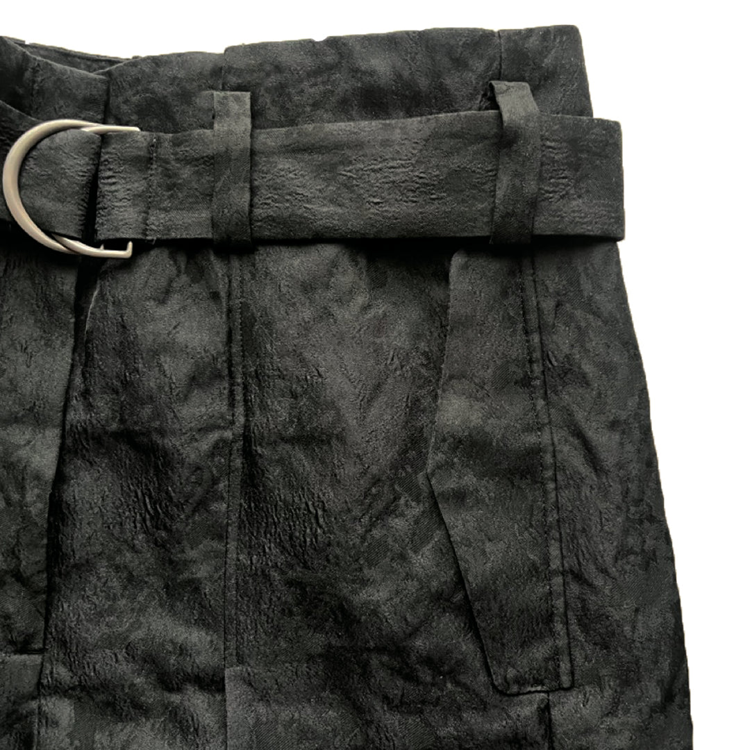 A close-up image of Katia Pleated Hakama Pants by Maison Lilli featuring a wide belt with a silver buckle, displayed against a white background.